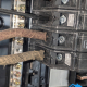 Close-up of frayed cloth electrical wiring connected to circuit breakers in an electrical panel.