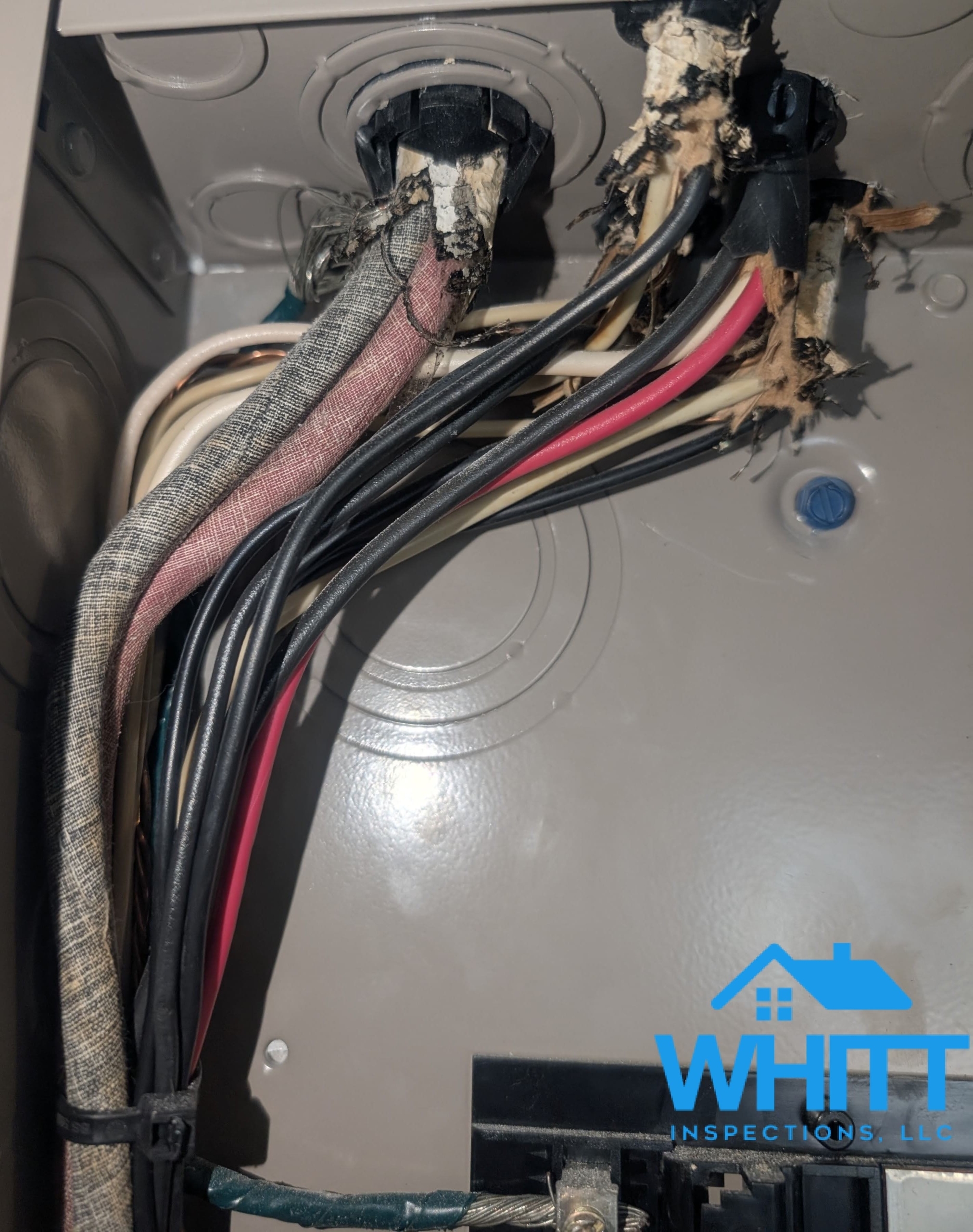 Cloth-insulated electrical wiring connected inside a circuit breaker panel.